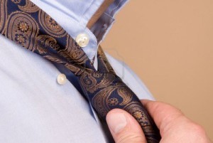 4360676-a-man-tying-his-necktie-in-preparation-for-work